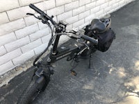 a black electric bike parked in front of a white wall